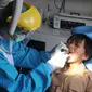 Dokter mencabut gigi murid baru sekolah dasar negeri di Puskesmas Pondok Labu, Jakarta Selatan, Rabu (12/8/2020). Selain dalam rangka Bulan Imunisasi Anak Sekolah, kegiatan ini juga bagian dari pemeriksaan kesehatan menyeluruh kepada murid baru sekolah dasar negeri. (merdeka.com/Arie Basuki)