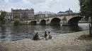 Orang-orang makan siang di tepi Sungai Seine, Paris, Prancis, Minggu (11/7/2021). Prancis telah mengakhiri kewajiban mengenakan masker di luar ruangan dan pencabutan jam malam sejak pertengahan Juni lalu menyusul penurunan kasus COVID-19. (AP Photo/Lewis Joly)
