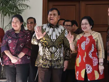 Ketua Umum Partai Gerindra Parbowo Subianto (dua kiri) dan Ketua Umum PDIP Megawati Soekarnoputri (dua kanan) melambaikan tangan jelang menggelar pertemuan di kediaman Megawati, Jalan Teuku Umar, Jakarta, Rabu (24/7/2019). Prabowo dan Megawati kompak memakai batik. (Liputan6.com/Helmi Fithriansyah)