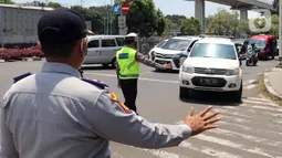 Polisi memberhentikan kendaraan saat pengendalian mobilitas ganjil genap untuk pengunjung TMII di Jalan Pintu 1 TMII, Jakarta, Sabtu (18/9/2021). Pembatasan mobilitas pada TMII dan Taman Impian Jaya Ancol dilakukan pada hari Jumat-Minggu mulai pukul 12.00-18.00 WIB. (Liputan6.com/Herman Zakharia)