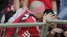 Pentolan suporter PSM Makassar, Daeng Uki, berusaha menenangkan anaknya yang menangis saat PSM Makassar takluk dari Persija Jakarta pada laga final Piala Indonesia di SUGBK, Minggu (21/7). Persija menang 1-0 atas PSM.  (Bola.com/M Iqbal Ichsan)
