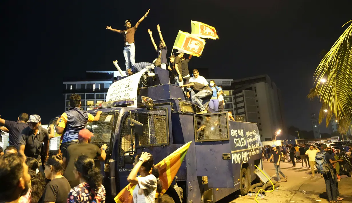 Para pengunjuk rasa berdiri di atas truk water canon polisi yang dirusak dan meneriakkan slogan-slogan di pintu masuk kediaman resmi presiden di Kolombo, Sri Lanka, 9 Juli 2022. Banyak orang di negara kepulauan berpenduduk 22 juta orang itu menyalahkan kemerosotan negara itu pada Rajapaksa. (AP Photo/Eranga Jayawardena)