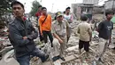 Warga berdiri di atas puing bangunan yang dibongkar di bantaran Sungai Ciliwung, Bukit Duri, Jakarta, Selasa (12/1). Pemprov DKI melakukan pembongkaran terhadap sejumlah bangunan terkait proyek normalisasi Sungai Ciliwung (Liputan6.com/ Immanuel Antonius)