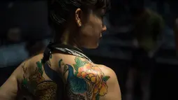 Seorang wanita memperlihatkan tato burung di bagian belakang tubuhnya saat menghadiri acara Langfang International Tattoo, di provinsi Hebei, China (2/5/2016). (AFP PHOTO / FRED Dufour)