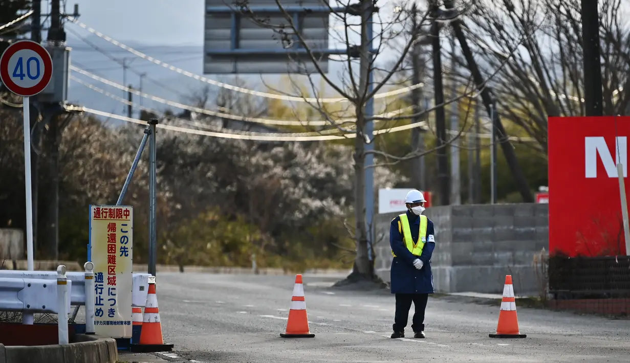 Foto ini diambil pada 29 Februari 2020 petugas mengontrol akses area terlarang di Tomioka, prefektur Fukushima, tepat di sebelah utara PLTN Daiichi Daiichi Fukushima yang rusak parah akibat gempa bumi dan tsunami 2011. (AFP/Charly Triballeau)