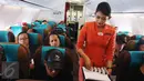 Pramugari membagikan cokelat kepada penumpang dalam penerbangan di Pesawat Garuda Indonesia menuju, Padang, Sumatera Barat, Jumat (21/4). Menyambut Hari Kartini, penerbangan Garuda Indonesia diawaki seluruhnya oleh perempuan. (Liputan6.com/Angga Yuniar)