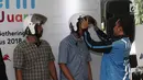 CEO Anterin.id Imron Hamzah memakaikan helm kepada driver saat peluncuran Anterin.id di Jakarta, Kamis (16/8). Layanan tarif nego di Anterin.id diklaim menjadi yang pertama di dunia. (Merdeka.com/Iqbal Nugroho)