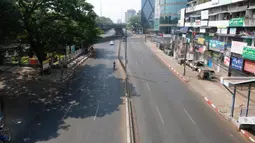 Seorang pengendara sepeda motor dan mobil melintasi jalanan yang kosong di pusat Kota Yangon, Myanmar, Rabu (24/3/2021. Demonstran antikudeta mencoba taktik baru yang mereka sebut pemogokan 'diam', menyerukan orang-orang untuk tinggal di rumah dan menutup bisnis. (AP Photo)