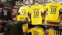 Seorang fans memilih jersey pemain baru Paris Saint Germain, Neymar Jr, di toko merchandise di Paris, Jumat (4/8/2017). Setelah resmi bergabung dengan Paris Saint Germain, jersey Neymar Jr langsung diburu suporter klub Ibu kota. (AP/Michel Euler)