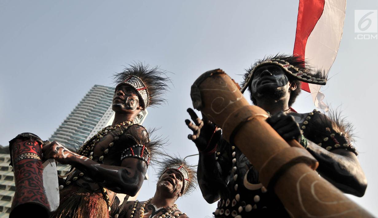 Masyarakat Papua yang merupakan mantan karyawan PT Freeport Indonesia saat melakukan penggalangan dana di tengah berlangsungnya Hari Bebas Kendaraan Bermotor atau Car Free Day di kawasan Bundaran HI, Jakarta, Minggu (5/8). (Merdeka.com/Iqbal S. Nugroho)