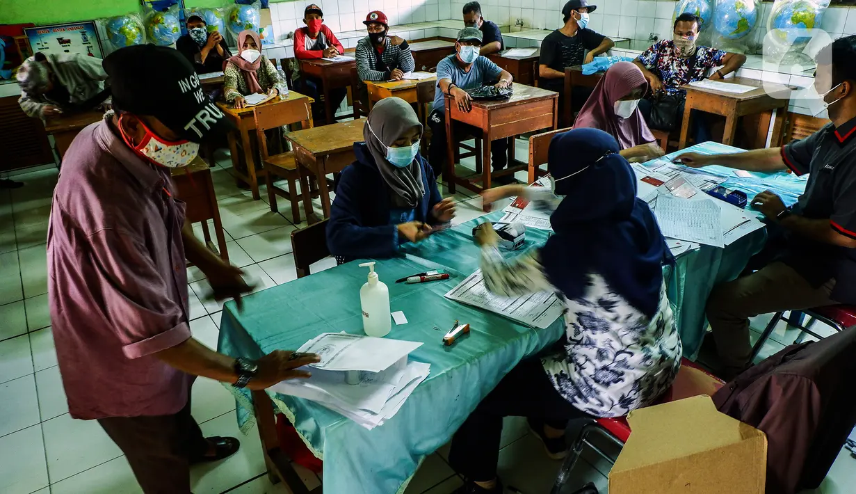 Suasana pencairan bantuan sosial tunai (BST) terhadap warga penerima manfaat di SDN Kembangan Utara 05 Pagi, Jakarta, Rabu (31/3/2021). Program BST sebesar Rp300 ribu dari Kemensos ini disalurkan melalui RT-RT se kelurahan Kembangan Utara melalui ATM Bank DKI. (Liputan6.com/Johan Tallo)