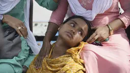 Jahanara Khatoon, 25 tahun, baru saja melahirkan di atas perahu dalam perjalanan mereka menuju sebuah pusat pelayanan kesehatan, dikelilingi oleh banjir yang melanda Sungai Brahmaputra. (AP Photo/Anupam Nath)