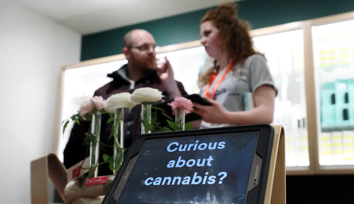 Karyawan membantu seorang pelanggan di toko Fire and Flower, Ottawa, Provinsi Ontario, Kanada, Senin (1/4). Fire and Flower merupakan toko ganja legal pertama di Provinsi Ontario. (REUTERS/Chris Wattie)