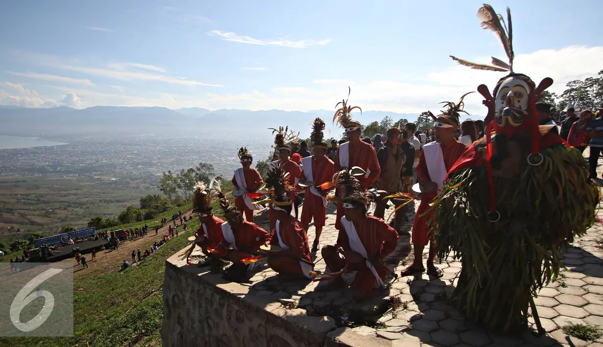 Seniman mementaskan tarian khas Toraja dan Dayak di Bukit Matantimali, Sigi, Sulawesi Tengah, Rabu (9/3). Tarian tersebut dilakukan dalam rangka menyambut gerhana matahari total serta menolak bala. (Liputan6.com/Immanuel Antonius)