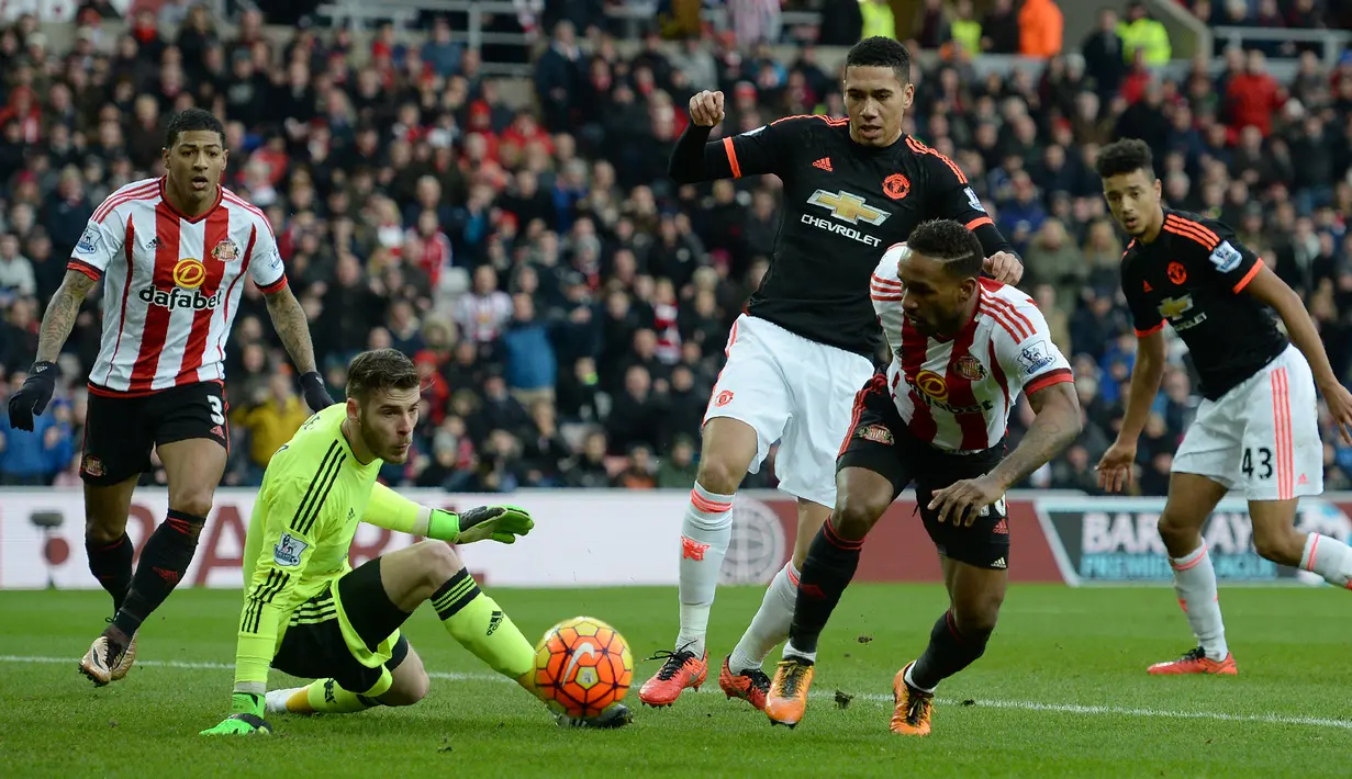 Kiper MU, David De Gea, berusaha menahan serangan pemain Sunderland, Jermain Defoe, dalam laga Liga Inggris di Stadium of Lights, Sunderland, Sabtu (13/2/2016) malam WIB. (AFP/Oli Scarff)