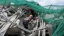 Seekor anjing pelacak dan para penyelamat menuruni reruntuhan selama operasi pencarian di sebuah bangunan yang runtuh di kota Angeles, provinsi Pampanga, utara Manila, Filipina, Senin 25 Mei 2026. (AP Photo/Aaron Favila)