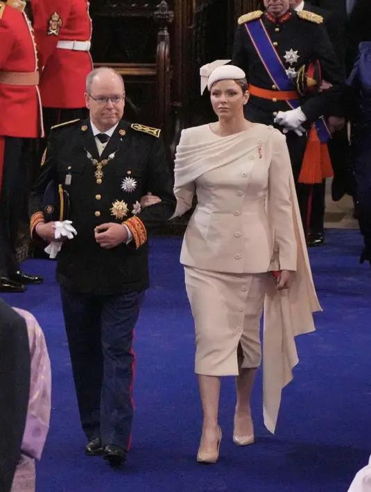Putri Charlene dari Monaco memilih warna pink pucat saat dia tiba di Westminster Abbey. Sang bangsawan mengenakan set rok krem yang menampilkan blazer berstruktur dengan detail kancing asimetris, selandang, dan rok midi yang serasi dengan belahan lutut. Topi kecil berbentuk cakram menahan potongan pixie yang baru saja diwarnai. @palaisprincierdemonaco