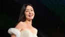<p>Aktris Korea Selatan Han Sun-hwa tersenyum saat berjalan di karpet merah saat upacara pembukaan Festival Film Internasional Busan (BIFF) ke-27 di Busan Cinema Center di Busan, Korea Selatan, Rabu, 5 Oktober 2022. (AFP/Jung Yeon-je)</p>