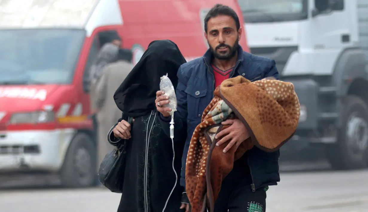 Seorang pria membawa anak dengan infus saat ia melarikan diri lebih dari wilayah yang dikuasai pemberontak di Aleppo, Suriah (12/12). (REUTERS / Abdalrhman Ismail)