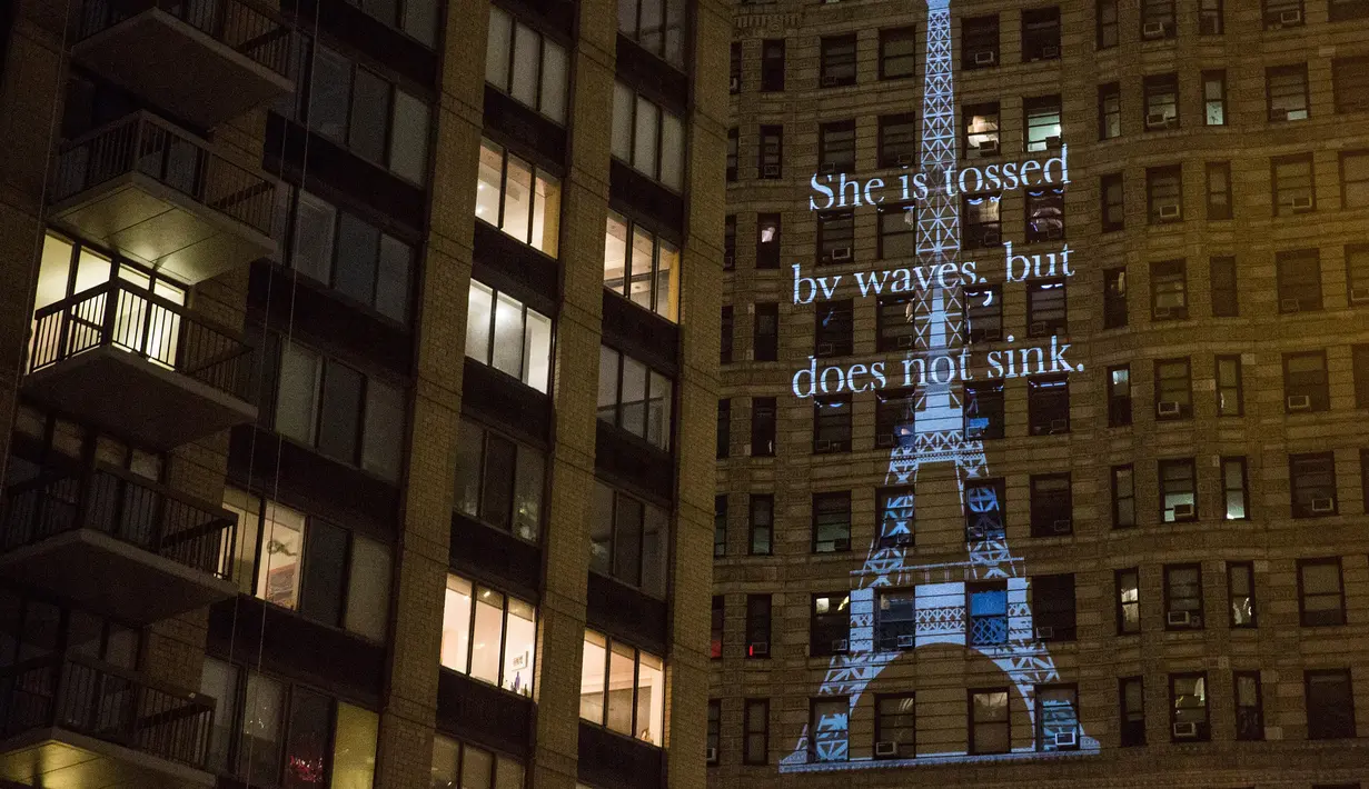 Proyeksi Menara Eiffel ditampilkan di sisi bangunan Flatiron New York City, Rabu (18/11). Gambar yang menampilkan tulisan 'She is tossed by waves but does not sink' itu bentuk solidaritas terkait serangan teror Paris. (Andrew Burton/Getty Images/AFP)