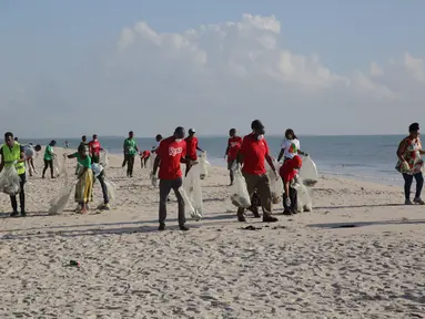 Para sukarelawan mengumpulkan sampah di sepanjang Pantai Kawe di Dar es Salaam, Tanzania (19/9/2020). Ratusan orang di seluruh kota tersebut berpartisipasi dalam upaya pembersihan sampah di pantai untuk memperingati Hari Bersih-Bersih Sedunia. (Xinhua)