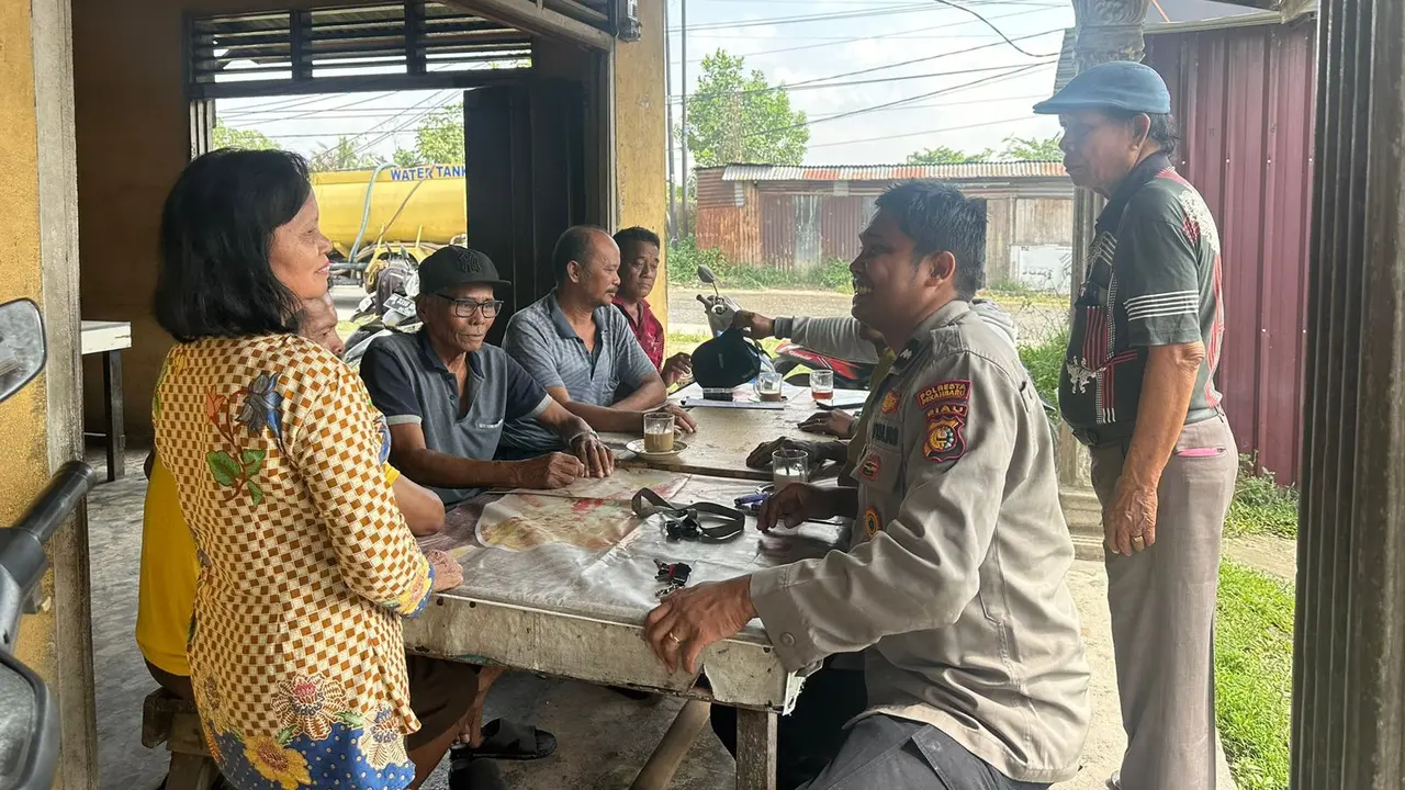 Personel Bhabinkamtibmas Polresta Pekanbaru duduk bersama warga membahas situasi keamanan masyarakat.