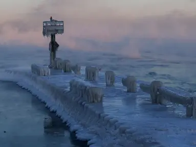 Sebuah lampu pelabuhan tertutup salju dan es di Danau Michigan di 39th Street Harbor, Chicago, Rabu (30/1). Cuaca dingin ekstrem yang terjadi sekali dalam satu generasi sedang melanda beberapa wilayah Amerika Serikat. (AP/Nam Y. Huh)