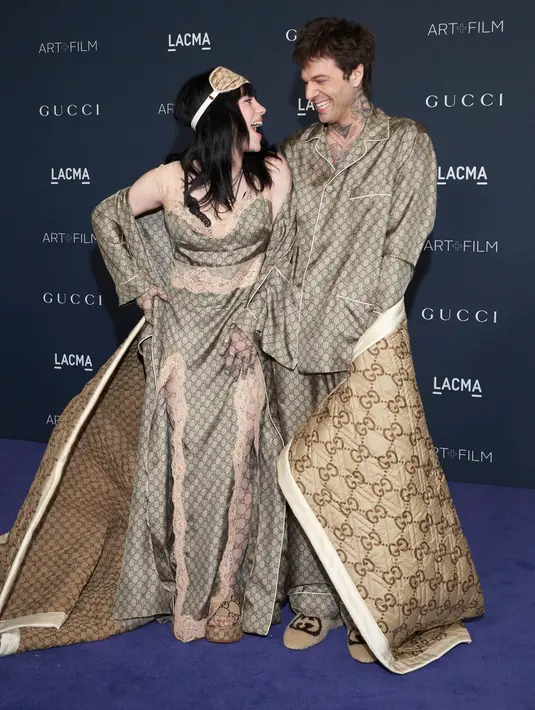 <p>Billie Eilish (kiri) dan Jesse Rutherford tiba pada acara LACMA Art+Film Gala di Los Angeles County Museum of Art, Los Angeles Amerika Serikat, 5 November 2022. Penyanyi "Happier Than Ever" berusia 20 tahun dan musisi The Neighborhood berusia 31 tahun itu tampil tidak biasa dengan selimut Gucci besar. (AP Photo/Allison Dinner)</p>