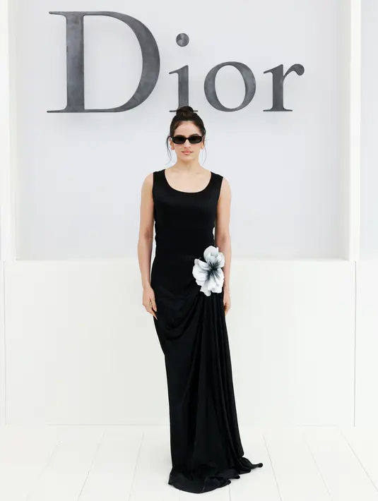 Rosalia tampil elegant effortless dengan sleeveless dress hitam beraksen bunga putih di pinggang [dok. Dior]