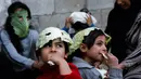 Anak-anak Palestina mengenakan masker yang terbuat dari kubis  saat bermain  di tengah pandemi Covid-19 di Beit Lahia di Jalur Gaza utara (16/4/2020). (AFP/Mohamed Abed)