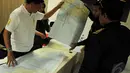 Petugas menunjukkan peta rute Surabaya menuju Singapura yang kemungkinan dilewati pesawat AirAsia QZ 8501 kepada salah satu kerabat penumpang pesawat tersebut, Surabaya, Minggu (28/12/2014). (Liputan6.com/Johan Tallo) 