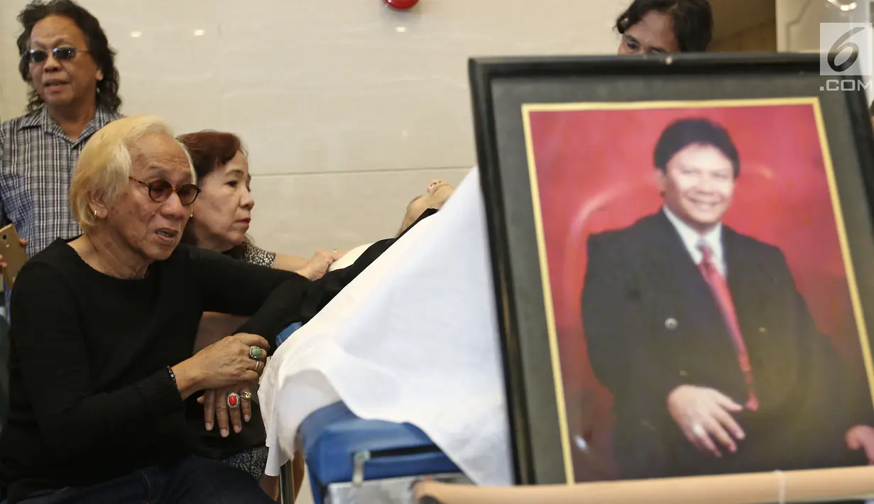 Adik kandung Benny Panjaitan, Asido Panjaitan memandangi jenazah kakaknya di rumah duka RS Dharmais, Jakarta, Selasa (24/10). Vokalis band Panbers itu meninggal di usia 70 tahun akibat penyakit stroke yang lama dideritanya. (Liputan6.com/Herman Zakharia)