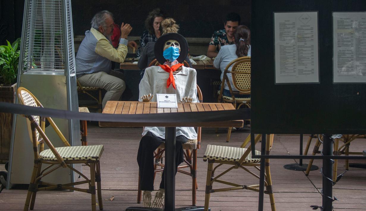 Pemandangan yang disebut Calaca (sosok tengkorak atau kerangka), yang biasa digunakan untuk dekorasi selama Day of the Death, di sebuah restoran di Coyoacan, Mexico City, Selasa (20/10/2020). Restoran tersebut menggunakan tengkorak untuk menjaga jarak di tengah pandemi COVID-19. (CLAUDIO CRUZ/AFP)
