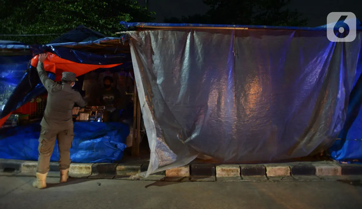 Petugas Satpol PP menertibkan pedagang kaki lima (PKL) di Kanal Banjir Timur, Jakarta, Kamis (28/5/2020). Petugas gabungan menertibkan ratusan lapak PKL karena buka pada masa Pembatasan Sosial Berskala Besar (PSBB) untuk menekan angka penyebaran COVID-19 di DKI Jakarta. (merdeka.com/Imam Buhori)