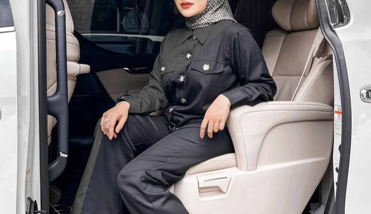Potret berikutnya, Nathalie tampil dengan setelan hitam dari kemeja lengan panjang dan celana panjangnya. Dipadukan kerudung segi empat bermotif lengkap dengan kacamata yang membuatnya nampak seperti sosialita. Credit: Instagram (@nathalieholscher)