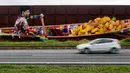 Sebuah mobil melintas didepan mural raksasa karya Eduardo Kobra di Itapevi, wilayah metropolitan Sao Paulo, Brasil (12/4). Karya ini merupakan mural terbesar di dunia dengan ukuran 5742 meter persegi. (AFP Photo/Nelson Almeida)