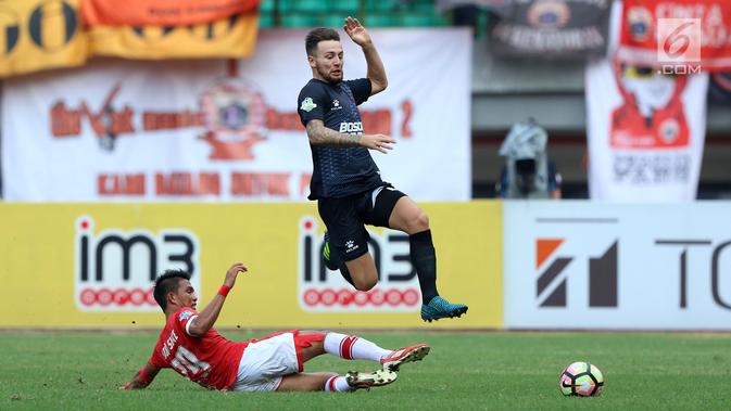 Bek PSM Makassar, Steven R A Paulle melompat menghindari tekel pemain Persija, Sandi Sute pada lanjutan Liga 1 Indonesia di Stadion Patriot Candrabhaga, Bekasi, Selasa (15/8). Laga berakhir imbang 2-2. (Liputan6.com/Helmi Fithriansyah)