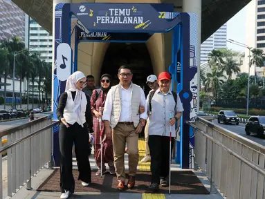 Bakal calon gubernur Jakarta, Ridwan Kamil (tengah) bersama Staf Khusus Presiden Bidang Sosial, Angkie Yudistia (kiri) saat kegiatan Jejak Langkah Inklusi RIDO bersama Teman Disabilitas di Halte Transjakarta Tosari, Jakarta, Jumat (13/9/2024). (Liputan6.com/Herman Zakharia)