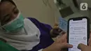 Tenaga medis mengecek nama penerima Covid-19 gratis dari pemerintah secara online di RSIA Tambak, Jakarta, Selasa (5/01/2021). Diketahui pemerintah mulai menjalankan persiapan untuk melakukan vaksinasi Covid-19 dengan mendata penerima tahap pertama. (Liputan6.com/Herman Zakharia)