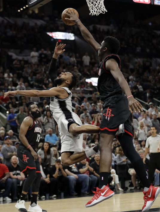 Aksi pemain San Antonio Spurs, Patty Mills (kiri) saat tembakannya diblok pemain Houston Rockets, Clint Capela pada gim kelima NBA basketball playoff series di San Antonio, (9/5/2017). Spurs menang 110-107. (AP/Eric Gay)