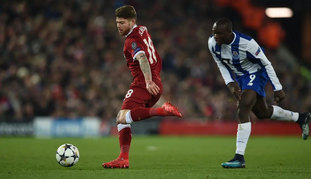 Bek Liverpool, Alberto Moreno berebut bola dengan striker FC Porto Vincent Aboubakar pada leg kedua babak 16 besar Liga Champions di Stadion Anfield, Selasa (6/3). Liverpool lolos ke perempatfinal berbekal kemenangan 5-0 secara agregat. (PAUL ELLIS/AFP)