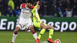 Duel gelandang Lyon, Martin Terrier dan Sergi Roberto pada leg 1, babak 16 besar Liga Champions yang berlangsung di stadion Parc Olympique Lyonnais, Lyon, Rabu (20/2). Barcelona bermain imbang 0-0 kontra Lyon. (AFP/Franck Fife)