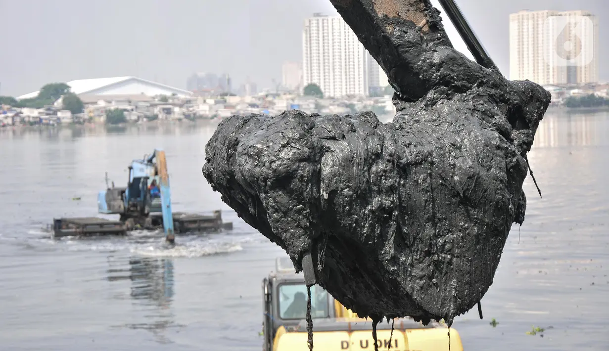 Alat berat mengeruk lumpur di Waduk Pluit, Senin (13/6/2022). Pengerukan lumpur rutin ini dilakukan sebagai upaya mengurangi endapan serta tanaman liar dan mencegah banjir di kawasan tersebut. (merdeka.com/Iqbal S Nugroho)