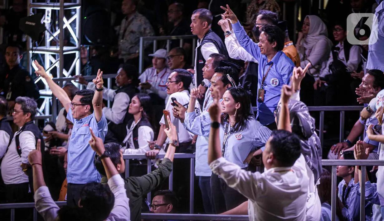 Pendukung pasangan calon presiden-calon wakil presiden pada Pemilu 2024 saat menyaksikan debat perdana Pilpres 2024 di halaman Gedung Komisi Pemilihan Umum (KPU), Selasa (12/12/2023). (Liputan6.com/Faizal Fanani)