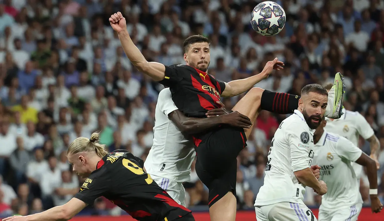 Bek Manchester City, Ruben Dias (tengah) berebut bola dengan bek Real Madrid, Dani Carvajal (kanan) pada laga leg pertama semifinal Liga Champions 2022/2023 di Santiago Bernabeu Stadium, Madrid (9/5/2023). Ruben Dias yang baru tiga musim membela Manchester City ini kini memiliki nilai pasar 75 juta euro atau setara Rp1,2 triliun. (AFP/Thomas Coex)