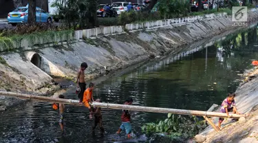 Anak-anak bermain di Kali Gresik di Jalan Muhammad Yamin, Menteng, Jakarta, Rabu (3/7/2019). Minimnya fasilitas bermain gratis, membuat anak-anak tersebut bermain ditempat yang tidak selayaknya. (Liputan6.com/Johan Tallo)