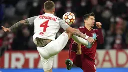 Pemain Salzburg Kamil Piatkowski (kiri) berebut bola dengan pemain Bayern Munchen Robert Lewandowski pada pertandingan leg kedua babak 16 besar Liga Champions di Munich, Jerman, 8 Maret 2022. Bayern Munchen menang 7-1. (AP Photo/Matthias Schrader)