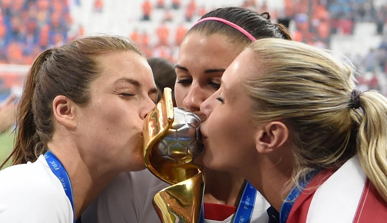 Para pemain Amerika Serikat mencium piala merayakan gelar juara Piala Dunia Wanita 2019 usai mengalahkan Belanda pada laga final di Stadion Lyon, Lyon, Minggu (7/7). AS menang 2-0 atas Belanda. (AFP/Phillippe Desmazes)
