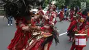 Peserta atraksi Tatung mengiris lidah dan leher peserta lainnya saat arak-arakan perayaan Cap Go Meh di kawasan Petojo, Jakarta, Selasa (19/2). Seorang Tatung harus puasa memakan daging dan menjadi vegetarian sebelum beraksi. (Liputan6.com/Angga Yuniar)