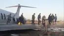 Penumpang berjalan di atas sayap pesawat Caspian usai tergelincir di jalan raya di Kota Bandar-e Mahshahr, Iran (27/1/2020). Maskapai Caspian Airlines yang membawa sekitar 150 penumpang dan kru pesawat tersebut terbang dari Bandara Mehrabad, Teheran. (Iran's Civil Aviation Network News via AP)